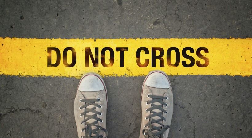 Close-up of shoes stopping at a drawn line, symbolizing the act of setting a personal boundary with clarity and self-respect.