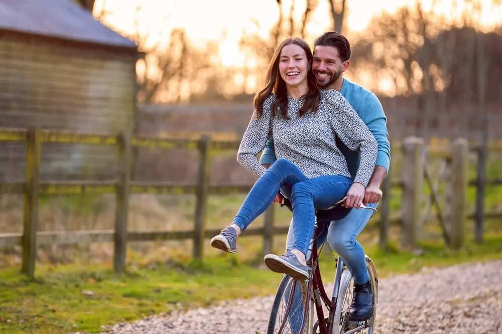 A man and woman riding a bike together, smiling and relaxed—capturing the simplicity and emotional depth of dating in your 30s.